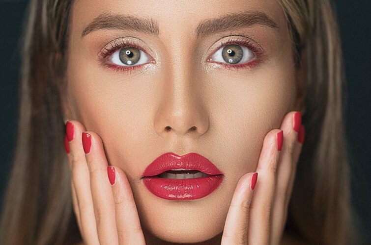 Model with a striking red manicure and matching red lips at Armani Nail Boutique, the best in the heart of Vancouver.