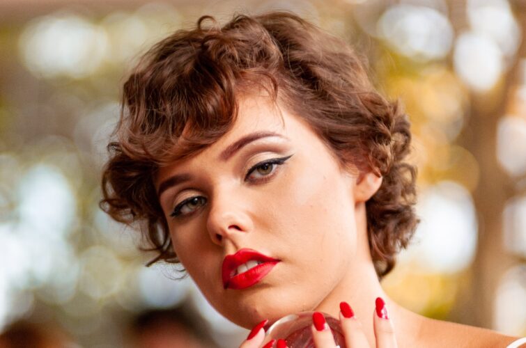 Model with classic red manicure holding a decorative object, at Armani Nail Boutique, the best in the heart of Vancouver.