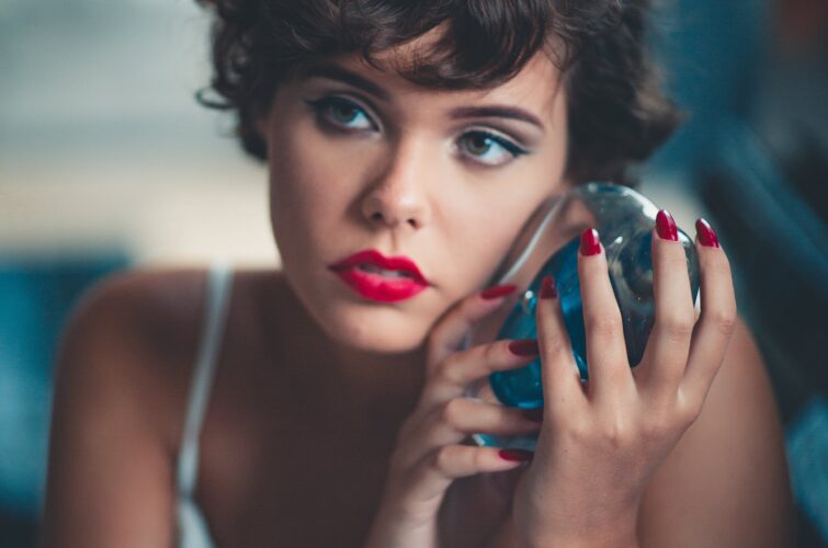 Model with classic red manicure holding a decorative object at Armani Nail Boutique, the best in the heart of Vancouver.