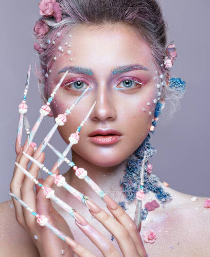 Close up of a model with uniquely designed long nails, artistic make up and decorative floral headpieces at Armani Nail Boutique, a premier North American salon.