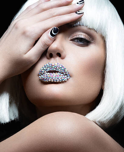 Close-up of a model with creative black and white nail designs and jeweled lips at Armani Nail Boutique, a top North American salon.