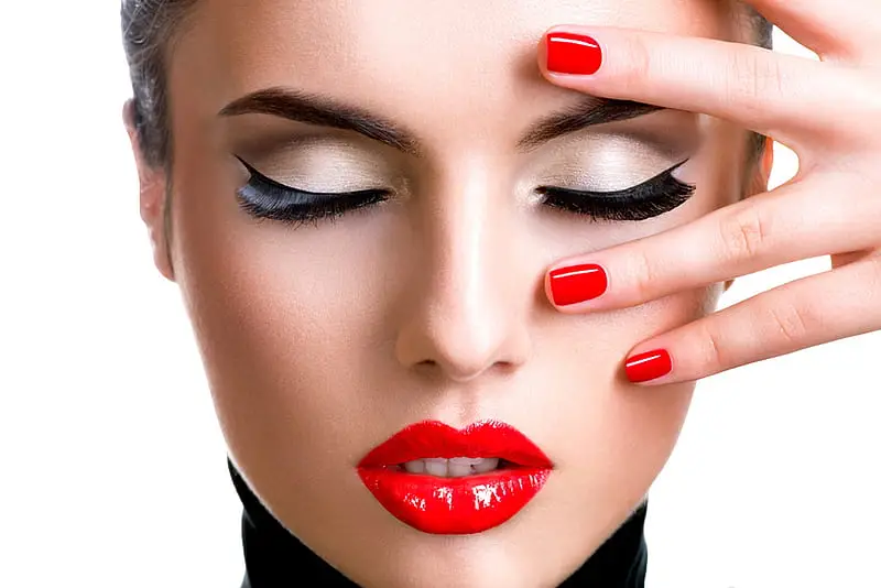 Close-up of a model showcasing a classic red manicure and elegant eye makeup, at Armani Nail Boutique, the best in the heart of Vancouver.