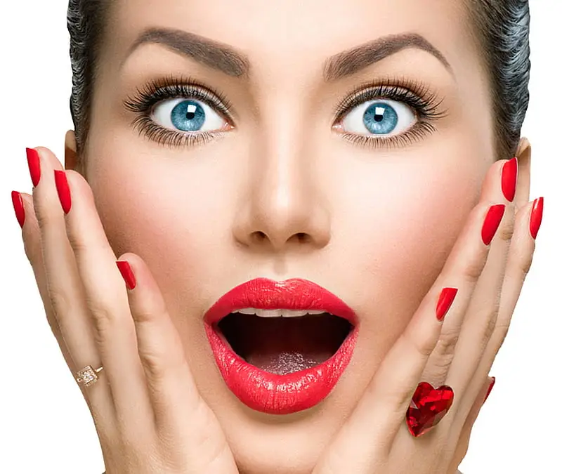 Model with surprised expression, showing off classic red manicure and red lips, at Armani Nail Boutique, the best in the heart of Vancouver.